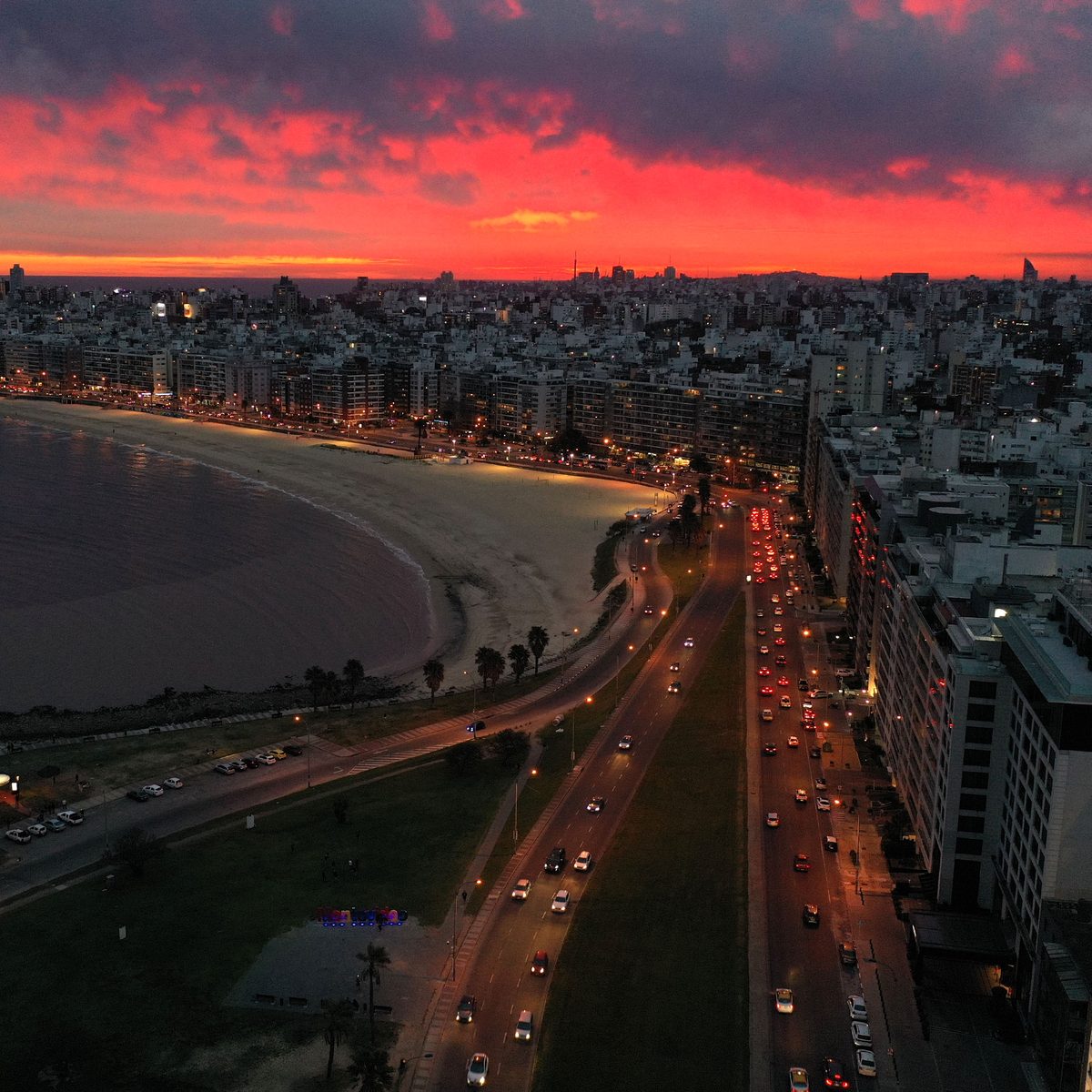 Aerial view of the Pocitos waterfront and beach in Montevideo at dusk, with the line of buildings facing the Río de la Plata.