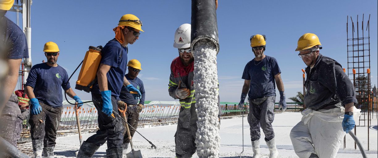Operarios durante el hormigonado de la losa de hormigón blanco en The Edge