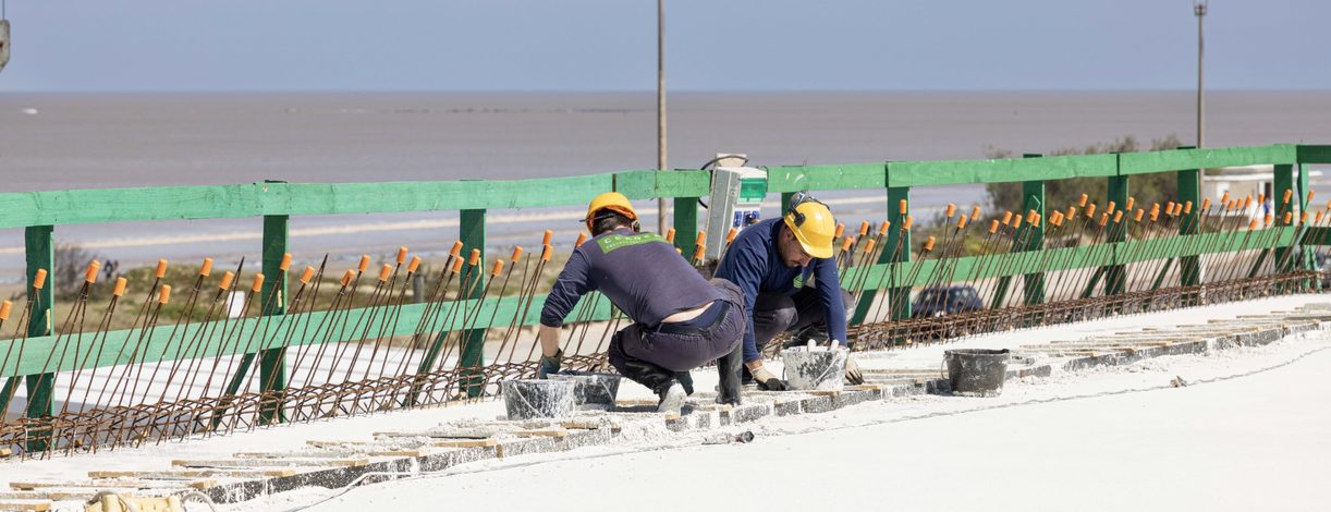 Operarios en el borde de la losa de The Edge, con vista al mar