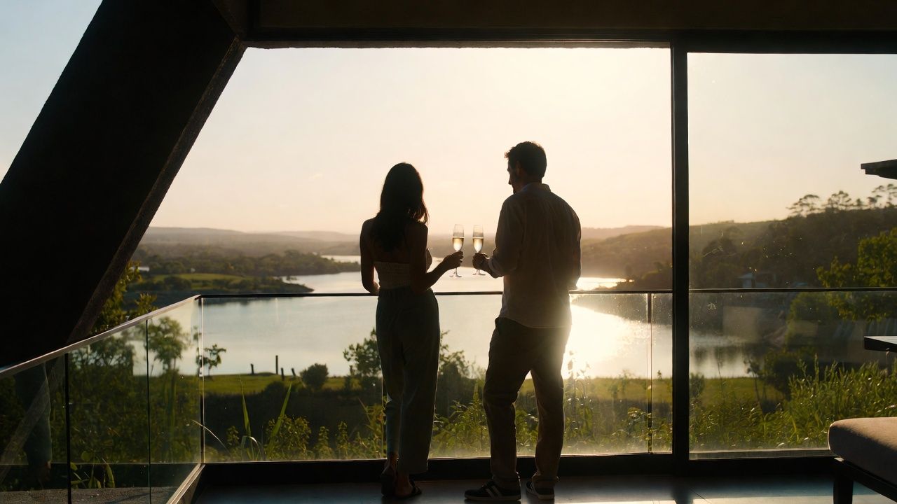 Couple toasting by a lagoon at sunset